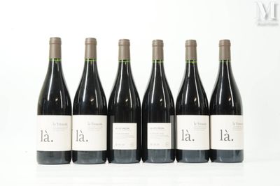 six bottles of wine are lined up on a white surface
