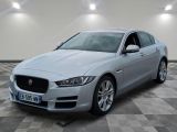 a silver jaguar parked in a room with checkered floor