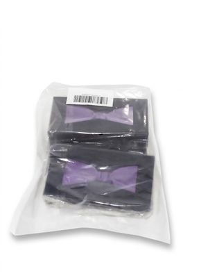 two bags of purple bow ties sitting on top of a white surface