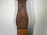 a tall wooden grandfather clock in a corner of a room
