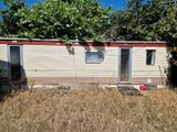 une photo d'un mobil-home au milieu d'un champ