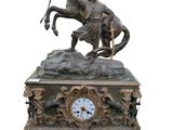une statue en bronze représentant un homme à cheval, avec une horloge
