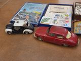 several toy cars are sitting on a table next to a box of dominos