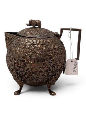 a large metal teapot with a tag on it