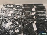 many bags of black clothing sitting on a table