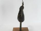 bronze sculpture of a bird on a wooden base
