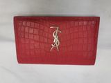 a red saint laurent wallet with gold monogramming