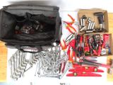 un sac rempli d'outils posé sur une table, à côté d'une paire de clés