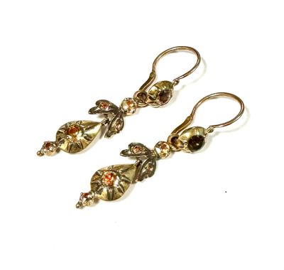 pair of gold tone earrings with garnets on them
