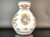a white vase with a gold and blue design on it