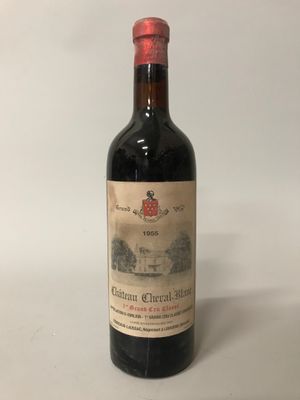 une vieille bouteille de vin posée sur une table blanche