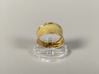 an image of a gold wedding ring on a clear stand
