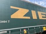 un grand camion vert avec un logo Ziel jaune sur le côté