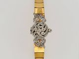 a close up of a gold and diamond watch on a white surface