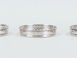 three silver rings sitting on top of each other on a white surface