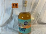 une bouteille d'alcool posée sur un lit, avec une étiquette indiquant le prix