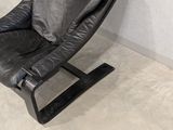 a black leather recliner chair in a corner of a room