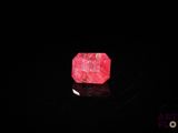 a pink stone in the dark with a black background