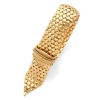a close up of a gold bracelet on a white background