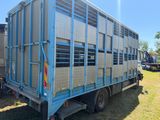 un camion bleu avec une remorque attelée à l'arrière