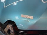 a close up of a blue car with a sticker on it ' s hood