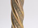 a close up view of a twisted metal candle holder