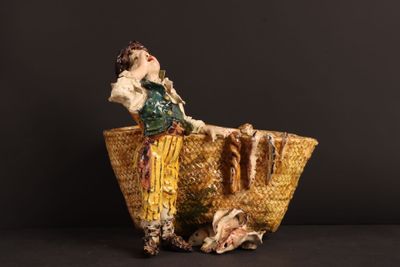 a figurine of a woman sitting in a basket