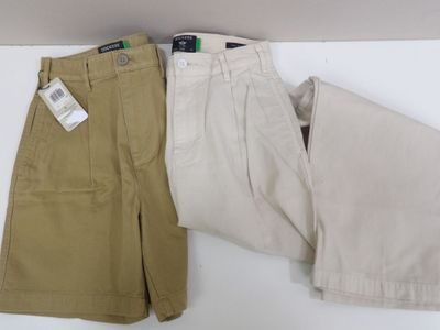 two pairs of men ' s pants sitting next to each other on a table