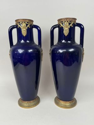 pair of blue vases with gold handles and handles on a white background