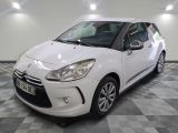 la petite voiture blanche est garée sur un sol en damier