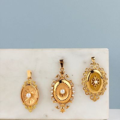 three gold lockes on a marble slab with a blue wall in the background