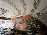 a mural on the ceiling of a restaurant with tables and chairs