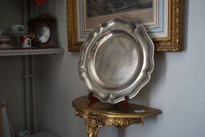 un plateau en argent posé sur une table en or devant un tableau