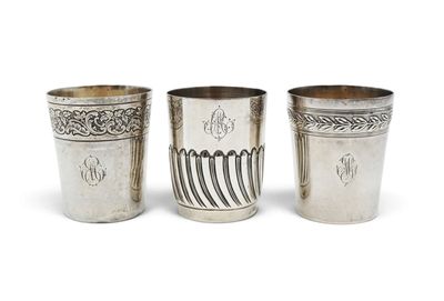 three silver cups with designs on them on a white background