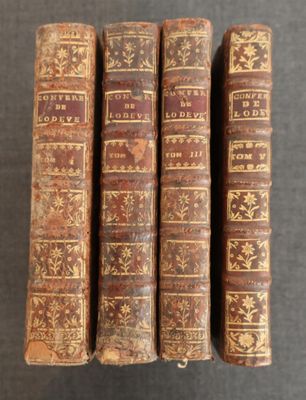 trois vieux livres posés l'un sur l'autre sur une table