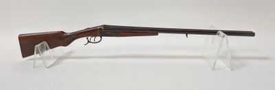 un fusil posé sur un socle transparent, devant un fond blanc