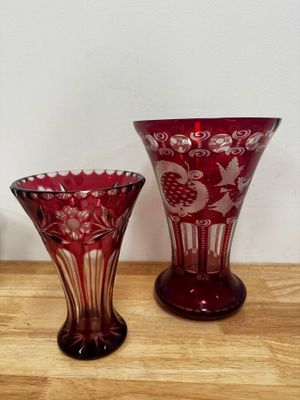 two red vases sitting on a table next to each other