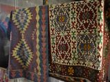 many different types of rugs hanging on a rack