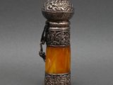 une bouteille ancienne en argent et en verre jaune, munie d'une anse
