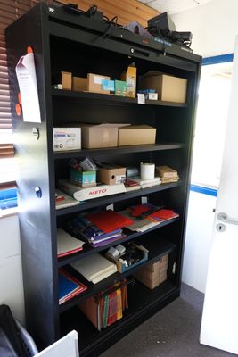 une bibliothèque noire sur laquelle sont posées de nombreuses boîtes