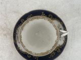a cup and saucer sitting on a white surface