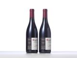 two bottles of red wine sitting on top of a table