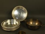 a group of silver dishes and cups on a black surface