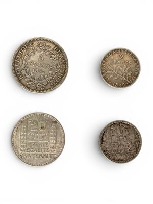 a group of five different coins on a white surface