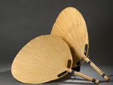 deux éventails en bois en forme de papillon posés sur une table