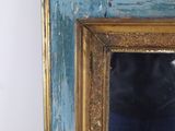 a blue and gold frame with a mirror on the wall