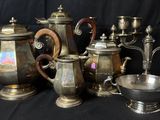 un assortiment de théières en argent et d'autres objets en argent sur fond noir