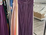 a purple dress hanging on a rack in a clothing store