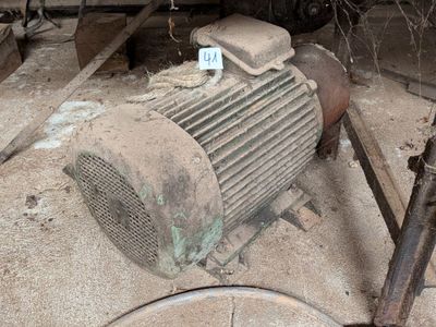 un vieux ventilateur posé par terre à côté d'un tas de vieilleries