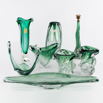trois vases en verre vert posés sur un plateau en verre